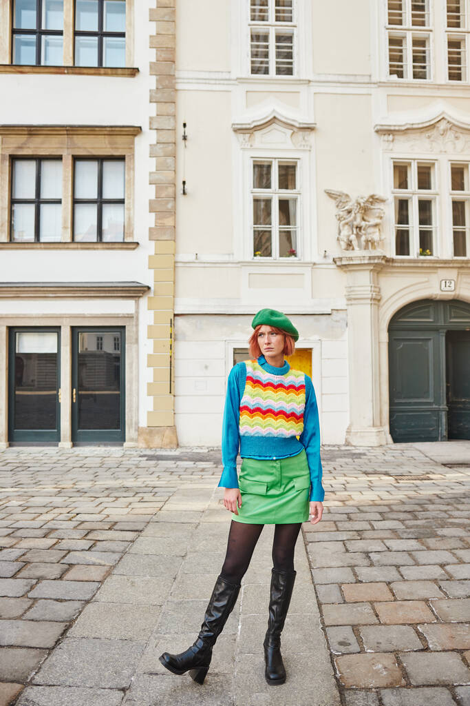 urbaani tyyli, trendikäs nainen baskerissa ja kirkas liivi etsii pois kadulla Wienissä, Itävallassa - Valokuva, kuva