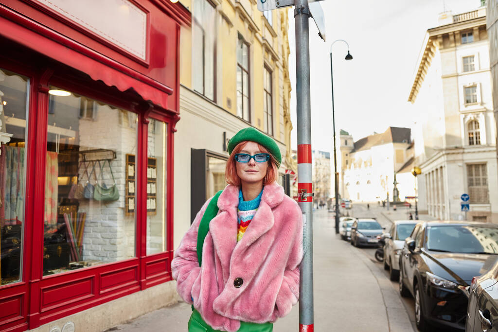 divatos nő műszőrme dzsekiben és napszemüvegben a bécsi City Street kameráját nézi, Ausztriában - Fotó, kép