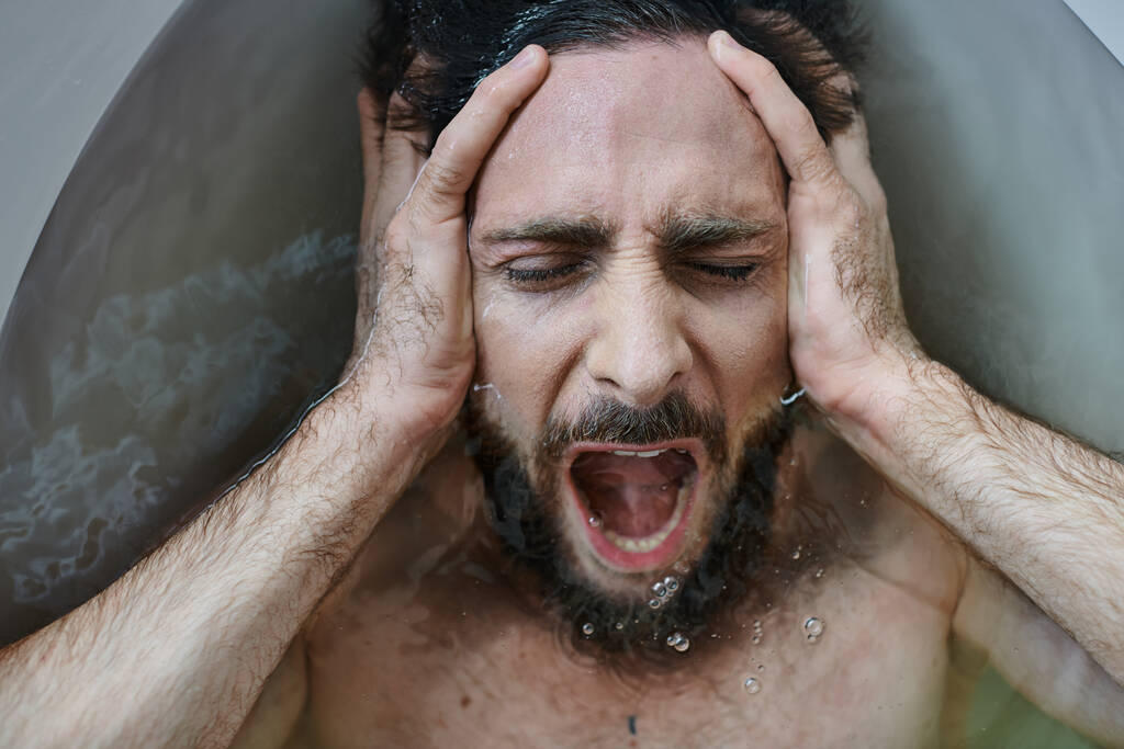 emotionaalinen traumatisoitunut mies makaa kylpyammeessa ja huutaa romahduksen aikana, mielenterveystietoisuus - Valokuva, kuva