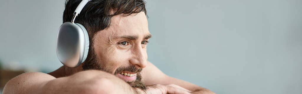allegro uomo con barba e cuffie seduto e rilassante nella sua vasca da bagno, salute mentale, banner - Foto, immagini