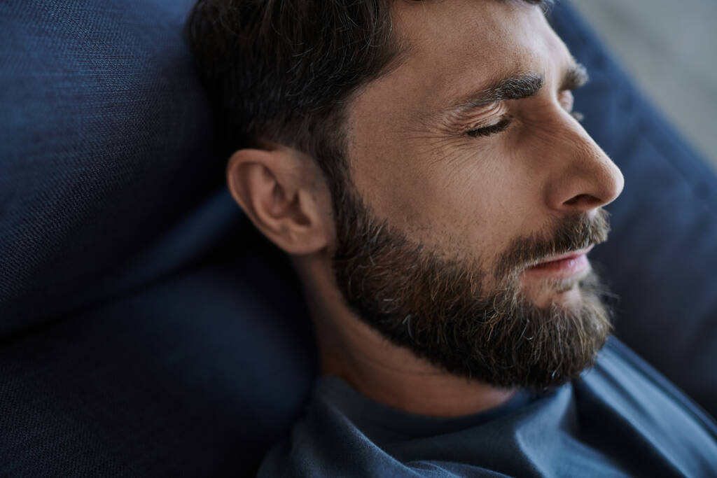 homem ansioso deprimido com barba em traje casual deitado no sofá durante colapso mental, consciência - Foto, Imagem
