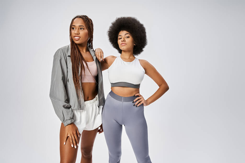 jovem e apto mulheres afro-americanas posando juntos em fundo cinza, conceito Juneteenth - Foto, Imagem