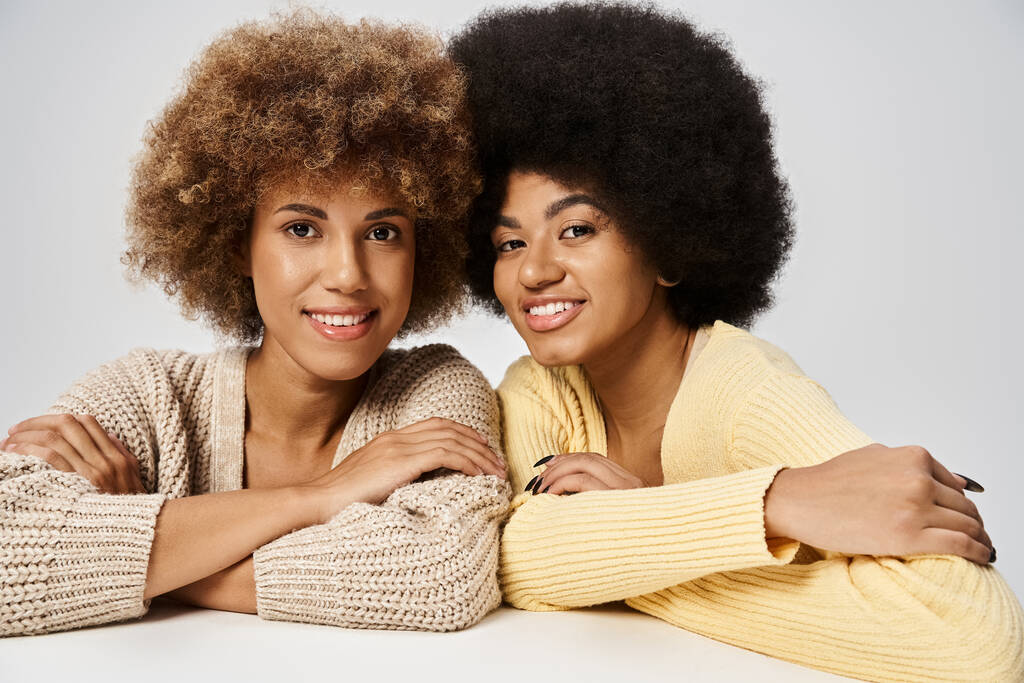 göndör és fiatal afro-amerikai barátok áll elegáns öltözékben szürke háttér, Juneteenth - Fotó, kép