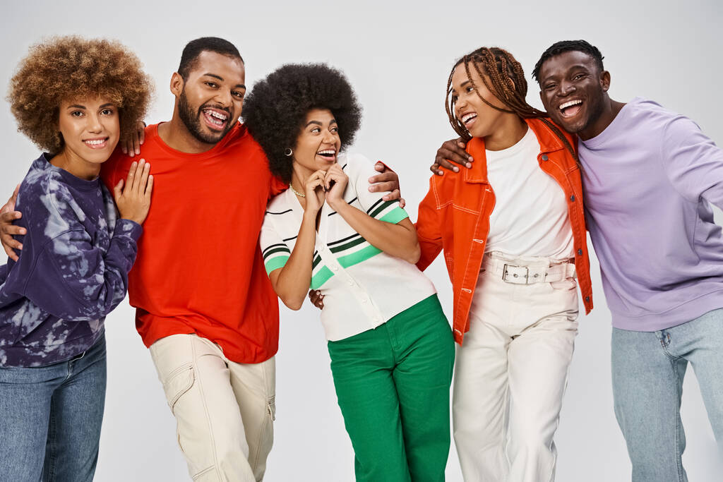 Ευτυχισμένοι αφροαμερικανοί άνθρωποι σε πολύχρωμο casual φορούν γελώντας μαζί σε γκρι φόντο - Φωτογραφία, εικόνα