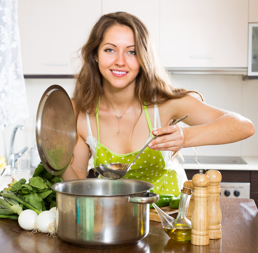 Mujer cocinando sopa en la cocina
 - Foto, imagen