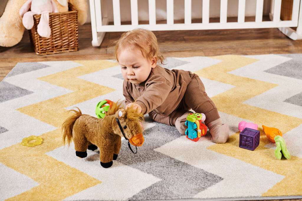 adorable dziecko i siedzi na podłodze i zabawy z zabawkami w przytulnym pokoju dziecinnym, szczęśliwe dzieciństwo - Zdjęcie, obraz