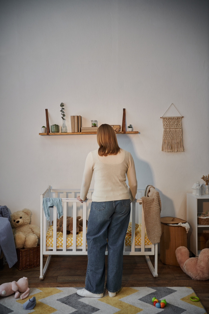 Yas tutan ve depresif bir kadının karyolasının yanında yumuşak oyuncaklar ve evde karanlık bir bebek odası. - Fotoğraf, Görsel