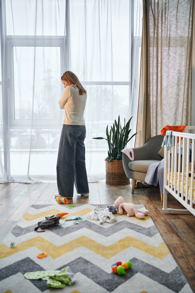 mulher deprimida de luto no quarto do berçário perto de brinquedos macios e berço do bebê em casa, frustração - Foto, Imagem