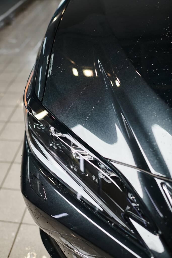 zdjęcie obiektu czarny nowoczesny samochód i jego reflektory zaparkowane w garażu podczas mycia - Zdjęcie, obraz