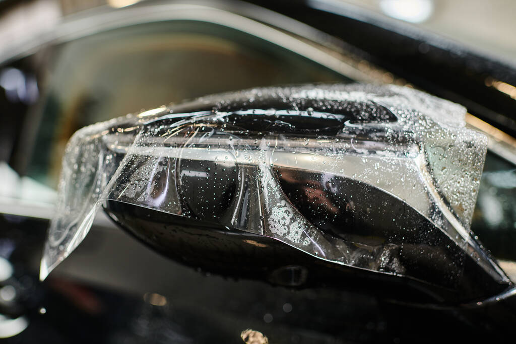zdjęcie obiektu przezroczysta folia ochronna nakładana na lusterko boczne czarnego nowoczesnego samochodu - Zdjęcie, obraz