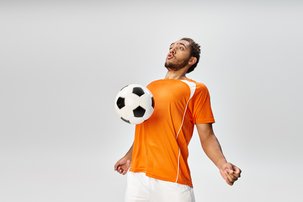 appealing athletic african american man in sportwear playing football actively on gray background - Photo, Image