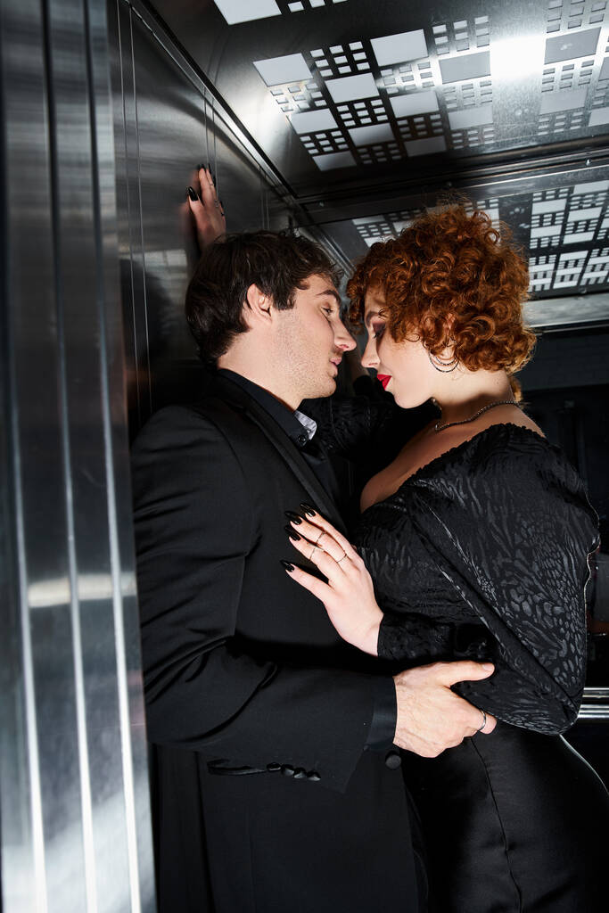 エレベーターで抱擁エレガントな黒の服装で愛する彼氏とガールフレンドを魅了, セクシーなカップル - 写真・画像