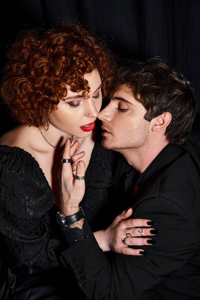 σαγηνευτικό αγόρι και κοπέλα με σικ ενδυμασία που φιλιούνται παθιασμένα σε μαύρο φόντο, σέξι ζευγάρι - Φωτογραφία, εικόνα