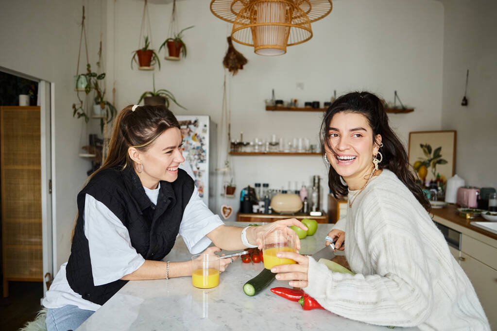 χαρούμενη και ζεστή στιγμή του νεαρού λεσβιακού ζευγαριού που περνάει χρόνο στην κουζίνα και φτιάχνει σαλάτα, Igbt - Φωτογραφία, εικόνα