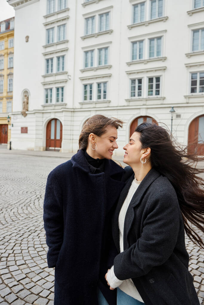 Інтимний момент веселої закоханої пари lgbt, що стоїть разом на вулиці в європейському місті - Фото, зображення