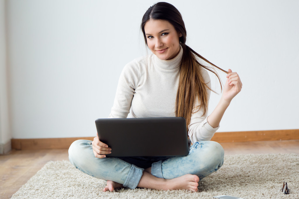 Schöne junge Frau arbeitet zu Hause an ihrem Laptop. - Foto, Bild