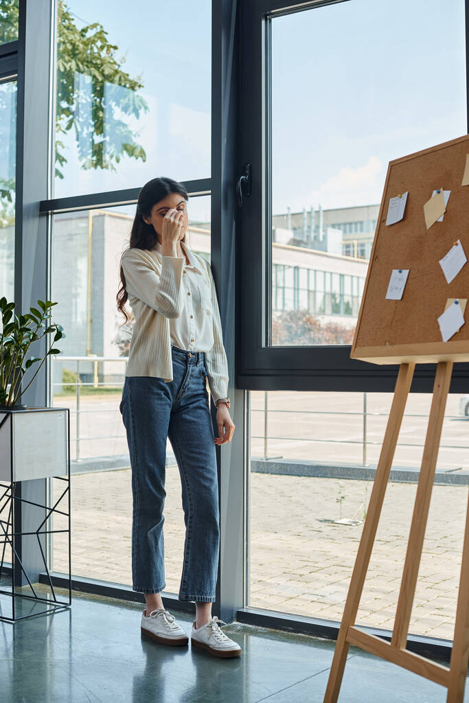 Μια σύγχρονη επιχειρηματίας στέκεται με αυτοπεποίθηση σε ένα γραφείο Franchise ρύθμιση. - Φωτογραφία, εικόνα