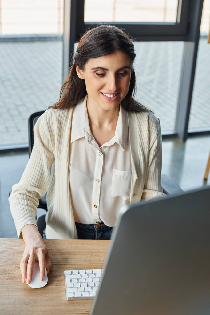 Modern bir ofis masasında işine dalmış bir iş kadını, bayilik kavramlarını yönetmek için bir bilgisayar kullanıyor.. - Fotoğraf, Görsel
