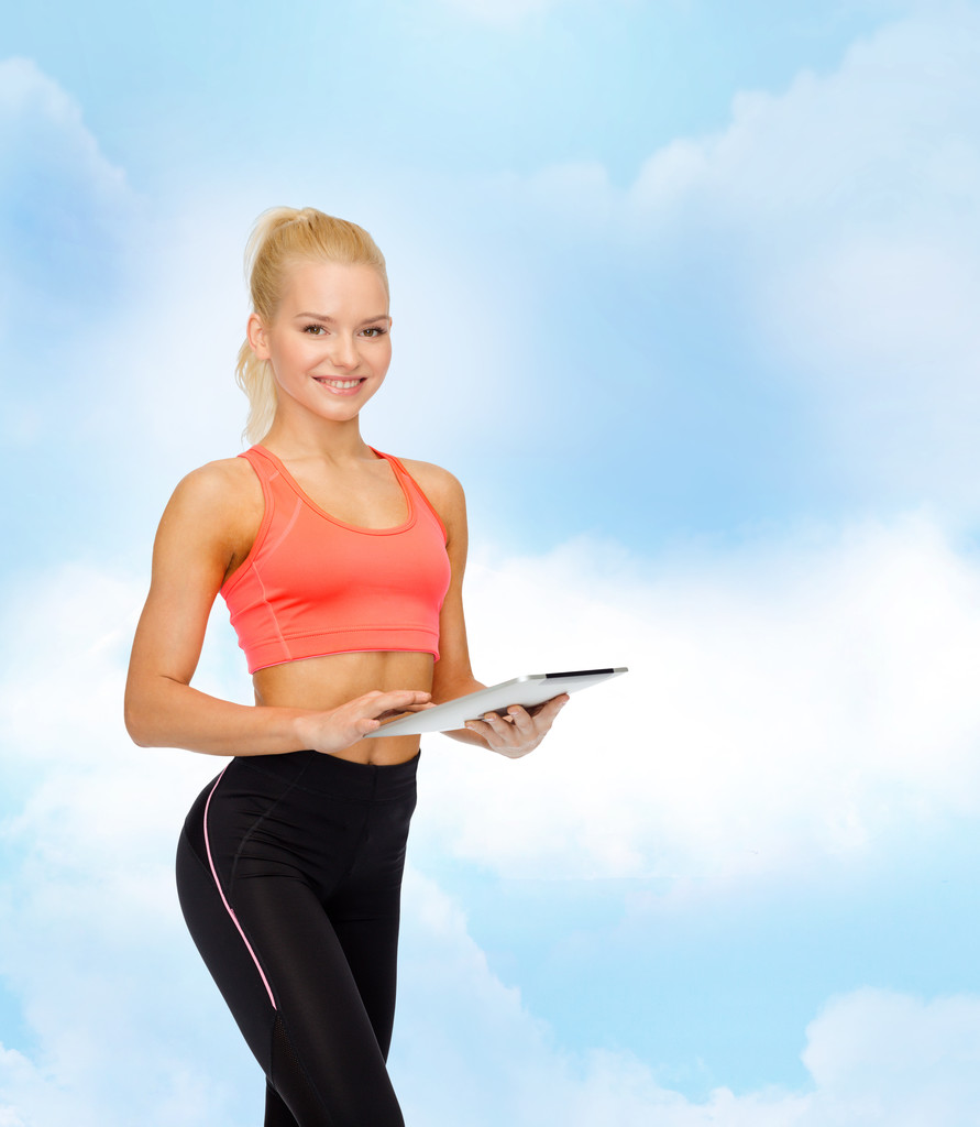 улыбающаяся спортивная женщина с планшетным компьютером
 - Фото, изображение