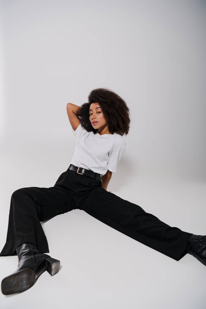 gyönyörű afro-amerikai női modell ül a padlón, és nézi a kamera, divat koncepció - Fotó, kép