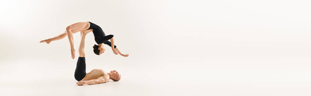 Bir kadın ve bir erkek akrobasi yaparak etkileyici bir denge gösterirler.. - Fotoğraf, Görsel