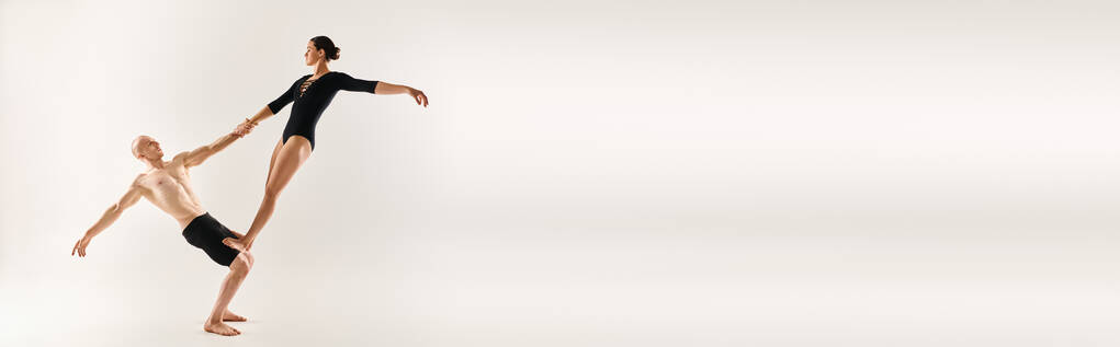 Молодой человек без рубашки и молодая женщина исполняют акробатические элементы в воздухе, демонстрируя изящный и завораживающий танец.. - Фото, изображение