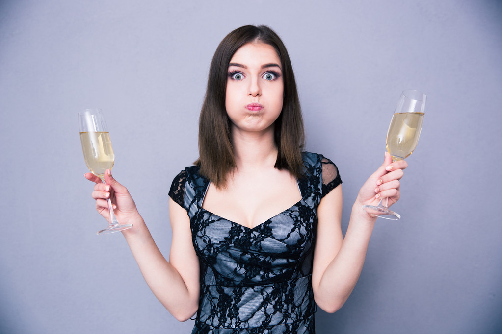Молодая красивая женщина держит два бокала с шампанским
 - Фото, изображение