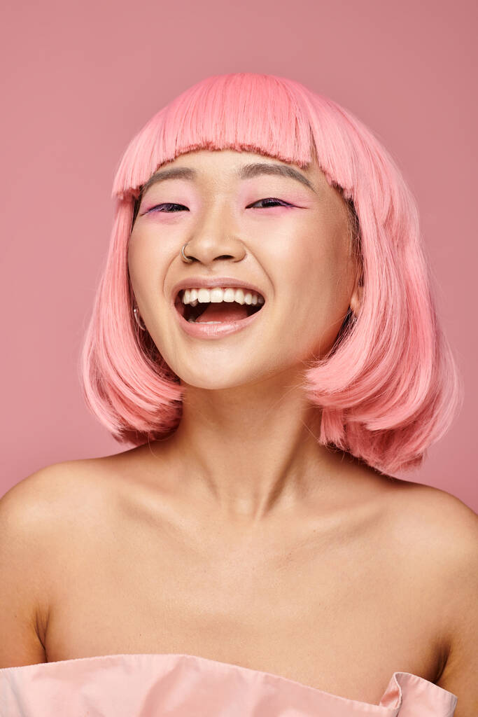 csinos fiatal nő rózsaszín haj és smink nevetés ellen élénk háttér - Fotó, kép