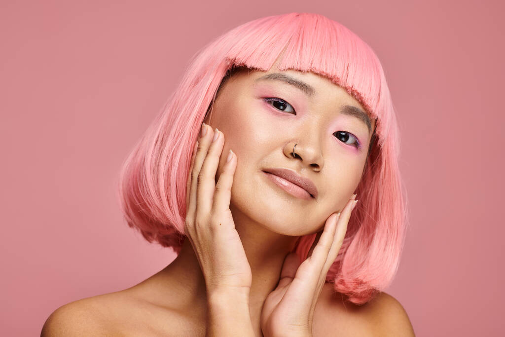 活気に満ちた背景に対して手でポーズピンクの髪を持つ魅力的なアジアの女性 - 写真・画像