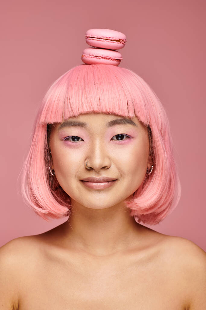 Porträt attraktive junge Frau mit rosa Haaren und Makronen auf dem Kopf auf lebendigem Hintergrund - Foto, Bild