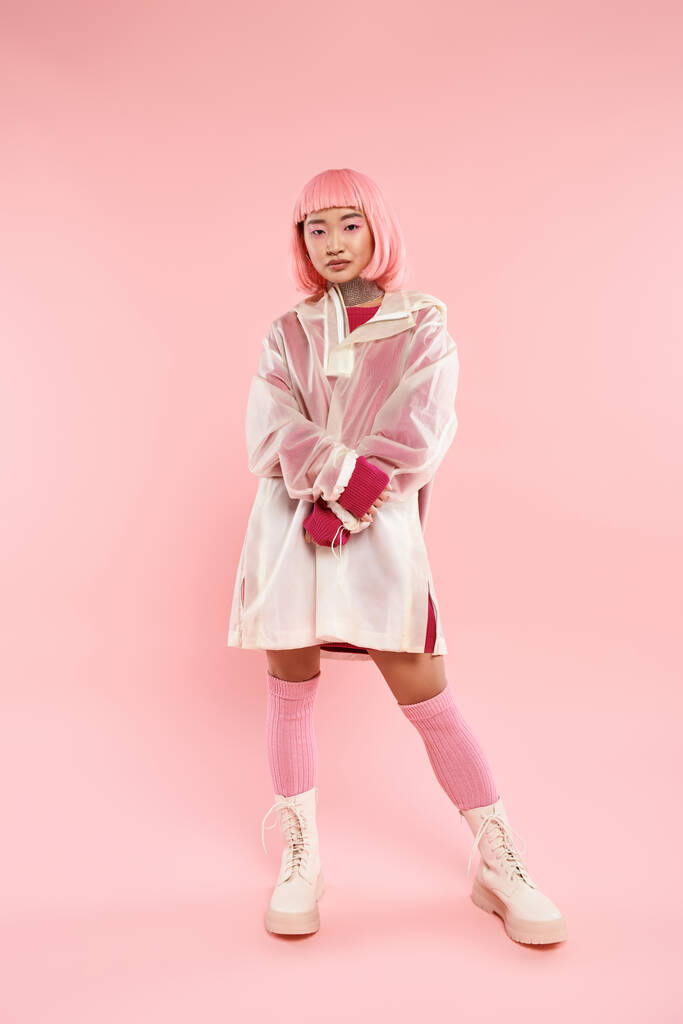 atractivo asiático joven mujer con rosa pelo y maquillaje en elegante traje contra vibrante fondo - Foto, imagen