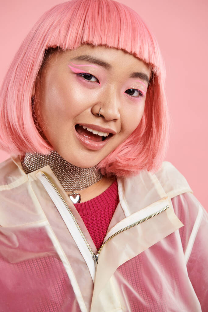 portrait of cute asian young woman with silver necklace, pink hair and makeup on vibrant background - Photo, Image