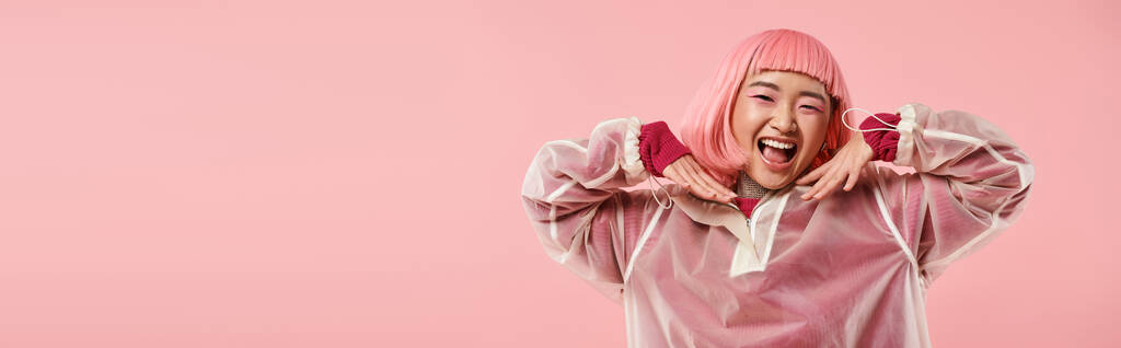 bandera de lindo asiático mujer con rosa pelo y maquillaje feliz sonriendo con las manos en vibrante fondo - Foto, imagen