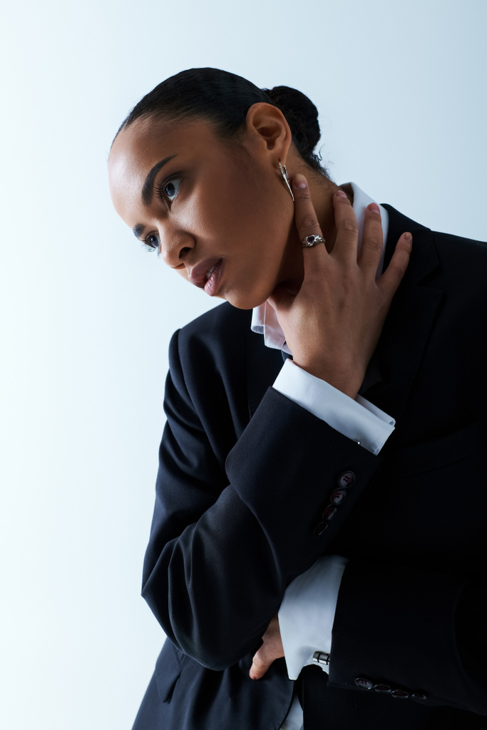 Giovane donna afroamericana sulla ventina indossa un abito nero affilato e una camicia bianca croccante. - Foto, immagini