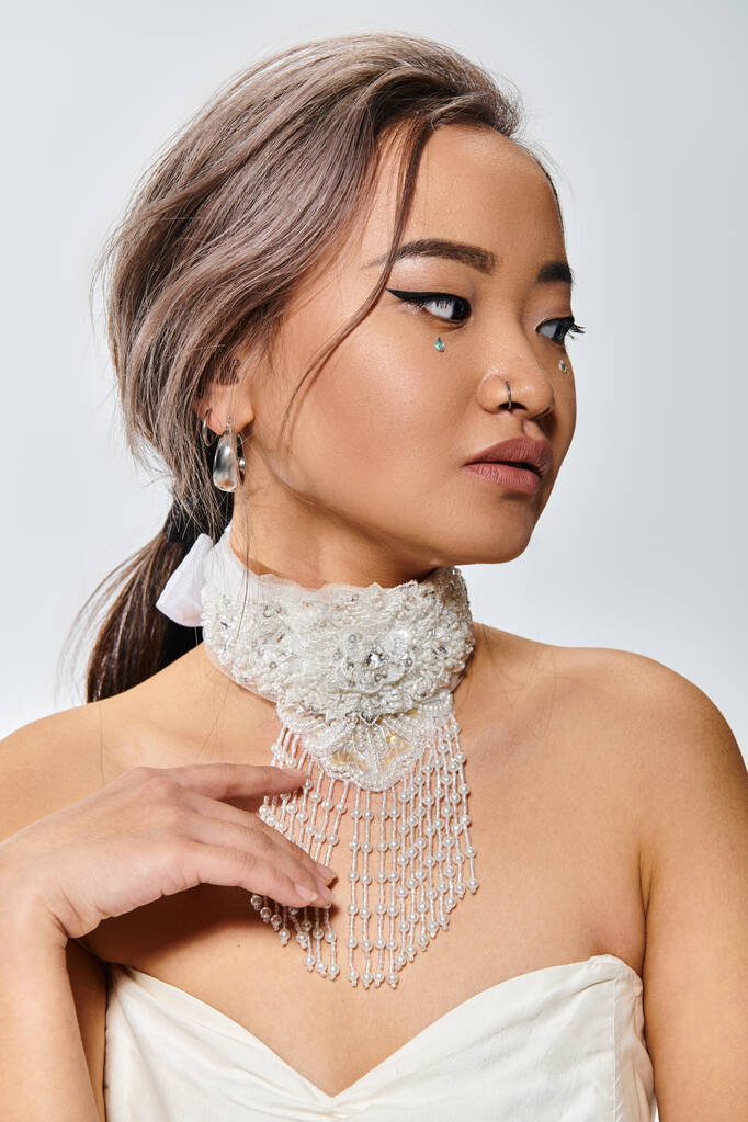 graciosa asiático noiva no ela 20s delicado tocar para branco colar contra luz fundo - Foto, Imagem