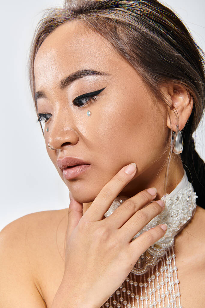 крупным планом с профилем привлекательная женщина с изяществом макияж и ожерелье деликатная поза с рукой - Фото, изображение