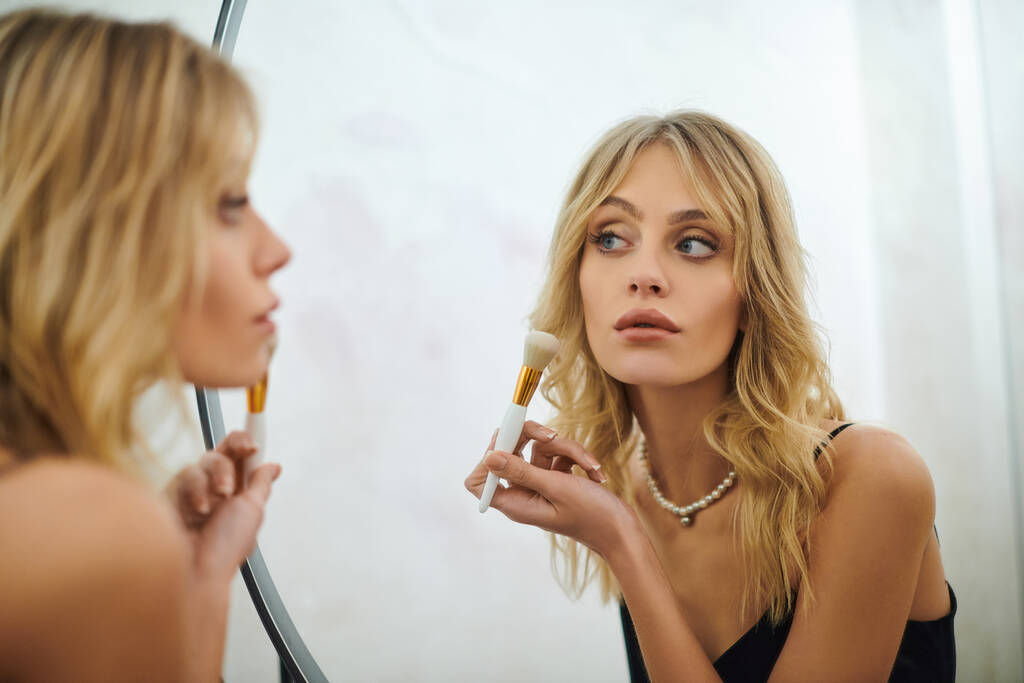 Una mujer mirando su reflejo en un espejo. - Foto, Imagen