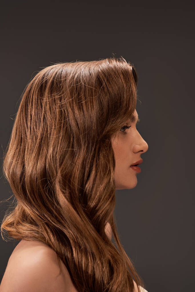 Portrait captivant d'une jeune femme aux beaux cheveux bruns et à la frange longue, respirant un air de mystère et d'allure. - Photo, image
