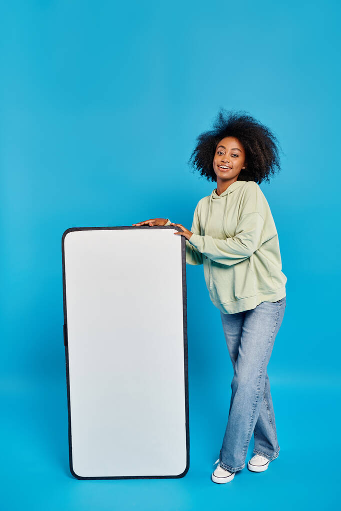 Egy nő magabiztosan áll egy hatalmas fehér tábla mellett, készen arra, hogy megossza az ötleteit és kreativitást ösztönözzön.. - Fotó, kép