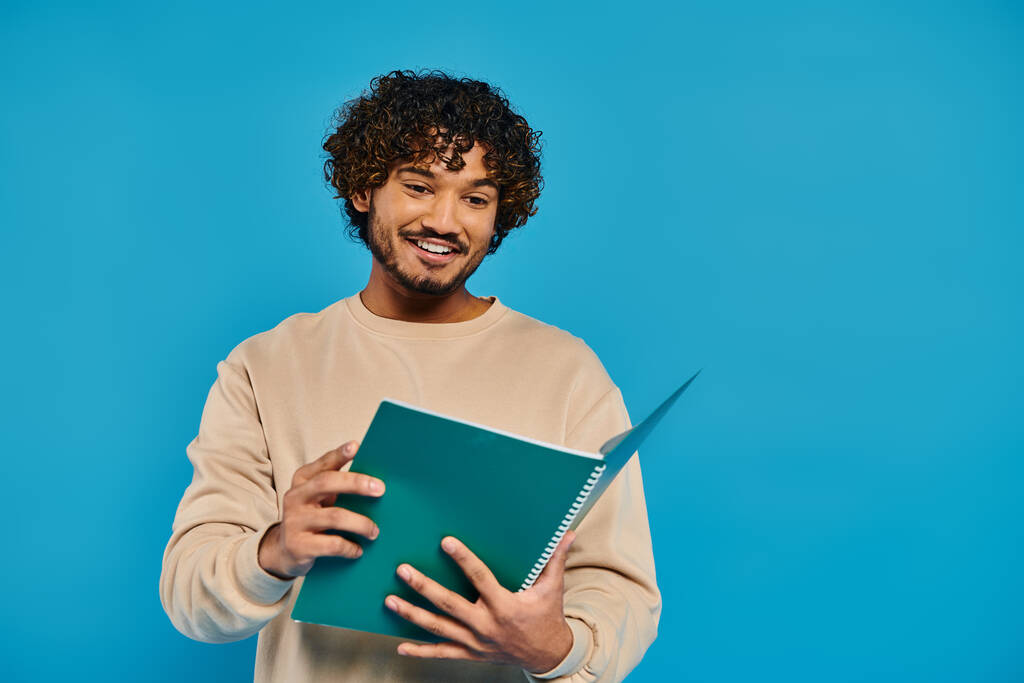 Een man die een boek vasthoudt terwijl hij glimlacht naar de camera, die geluk en kennis belichaamt. - Foto, afbeelding