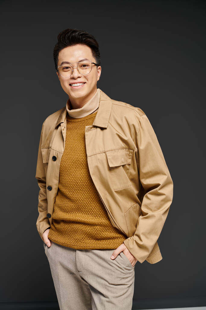 A stylish young man wearing glasses and a tan jacket poses elegantly in this vibrant portrait. - Photo, Image