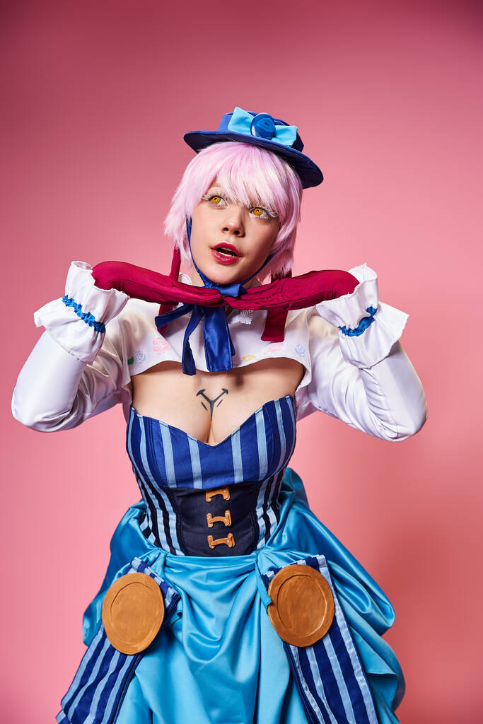 vonzó divatos nő cosplaying aranyos anime karakter és elnézett rózsaszín háttér - Fotó, kép