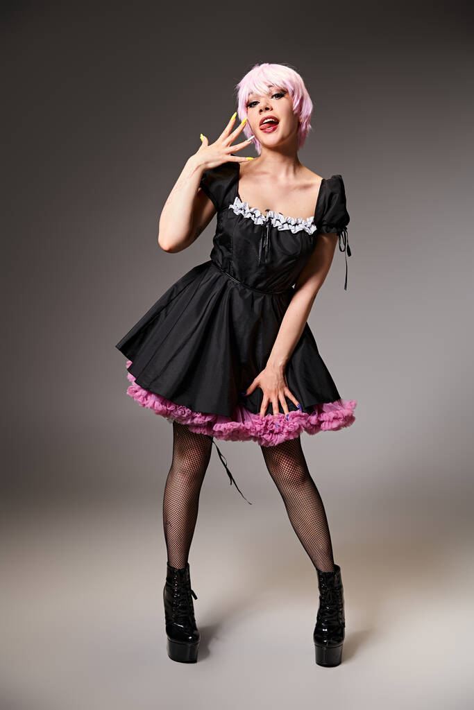 wesoły kuszące kobieta cosplayer w żywe sukienki wystające jej język i patrząc w aparat - Zdjęcie, obraz
