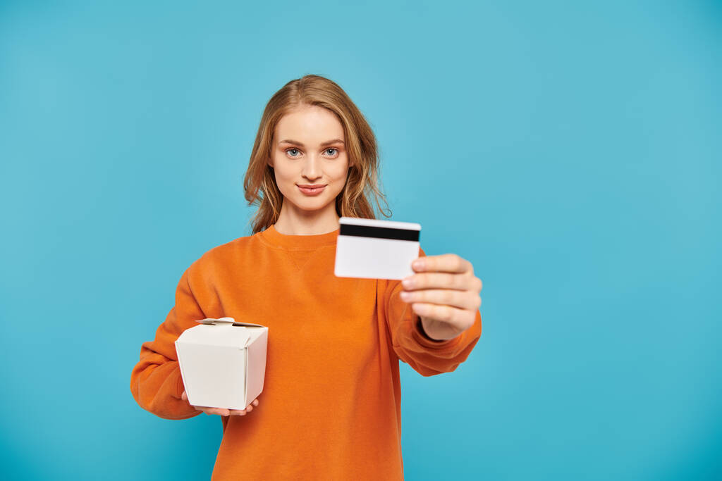 Femme élégante tenant une carte de crédit et une boîte de nourriture asiatique. - Photo, image