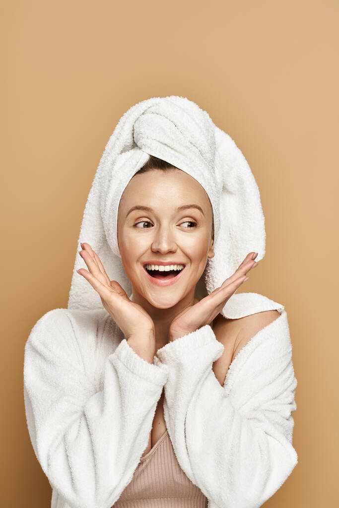 Una mujer impresionante, radiante belleza natural, lleva una toalla en la cabeza en una pose real. - Foto, Imagen