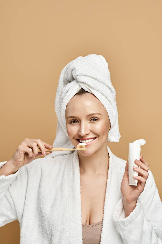 Eine Frau mit natürlicher Schönheit beim Zähneputzen, während sie ein Handtuch auf dem Kopf trägt. - Foto, Bild