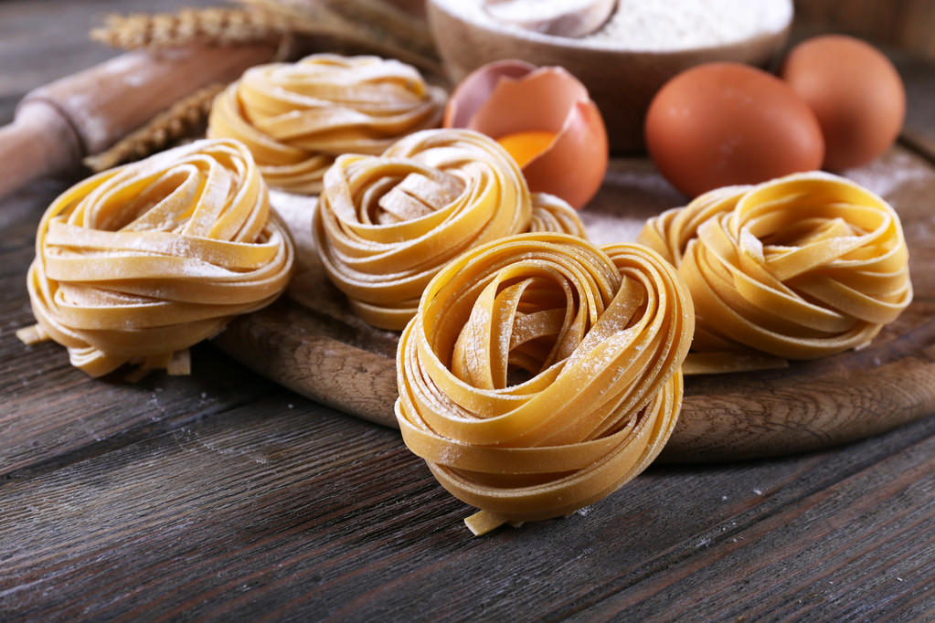 Raaka kotitekoinen pasta ja ainekset pastaa puinen tausta
 - Valokuva, kuva