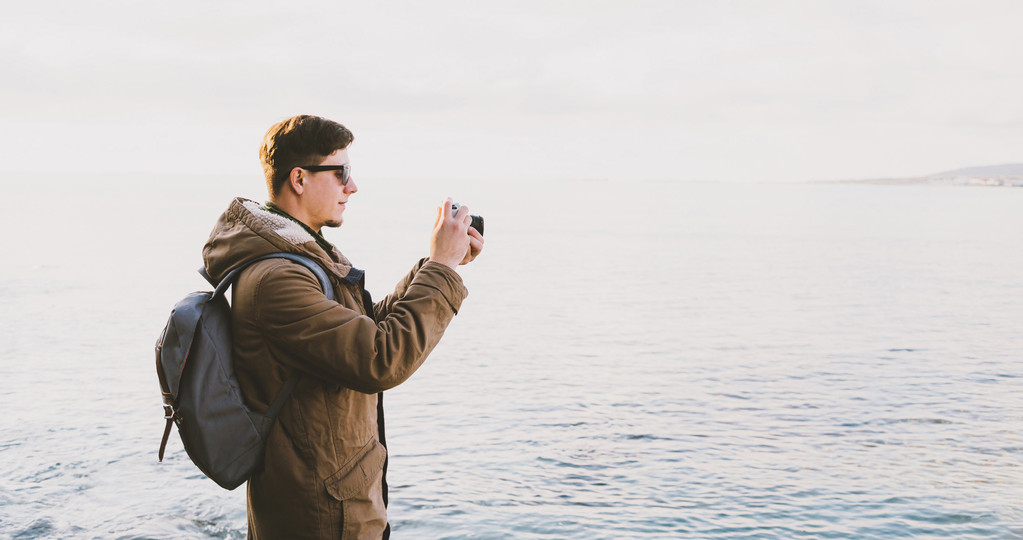 Νεαρός άνδρας, λήψη φωτογραφιών στην παραλία - Φωτογραφία, εικόνα
