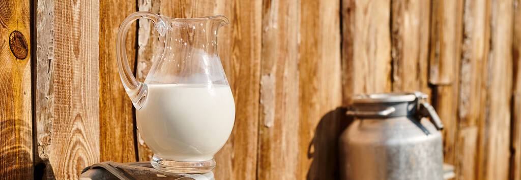 Objektfoto von Urne und Glas mit frischer Milch vor dem Dorfhaus auf modernem Bauernhof platziert, Banner - Foto, Bild