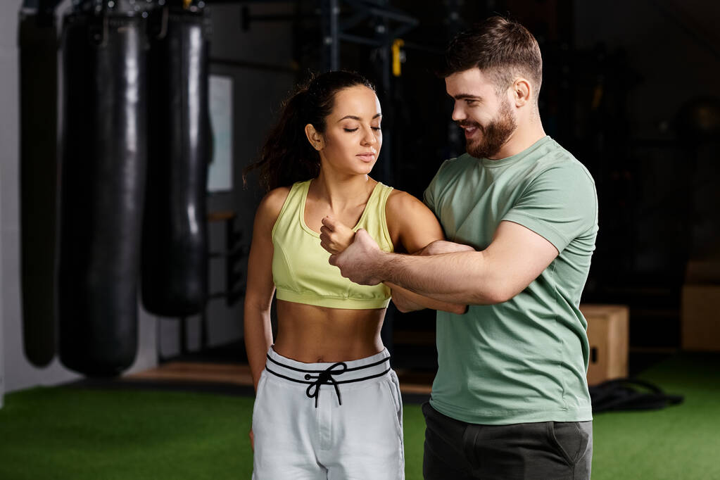 Un entrenador masculino demuestra técnicas de autodefensa a una mujer en un entorno de gimnasio, haciendo hincapié en la seguridad y el empoderamiento. - Foto, imagen
